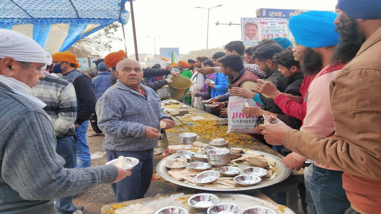 Protesters enjoy langar food during tractor rally in New Delhi. Pic/Diwakar Sharma