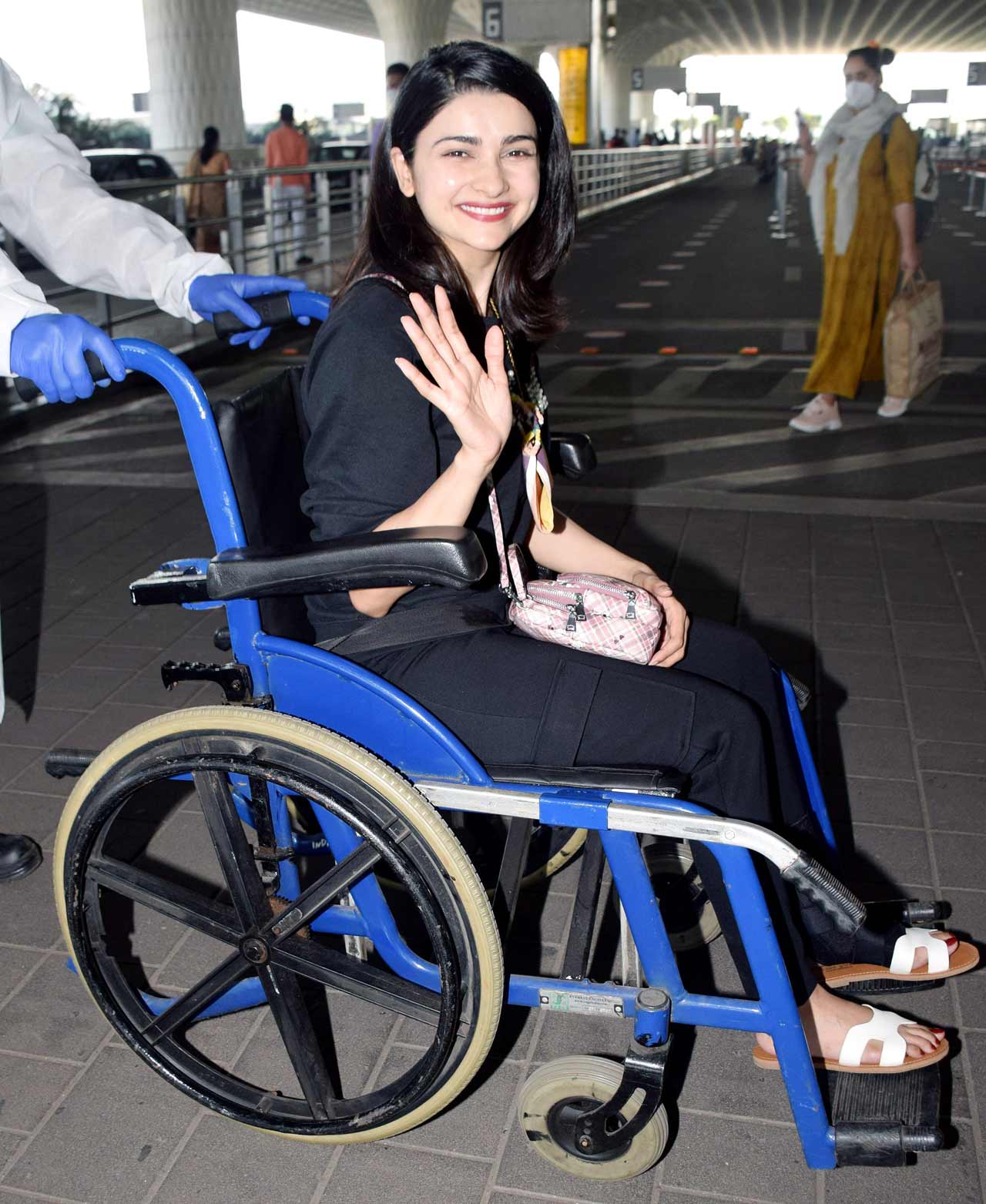 Prachi Desai waved at the paparazzi when snapped at the Mumbai airport. The actress was seen sitting on a wheelchair, as she broke her feet a while ago.
