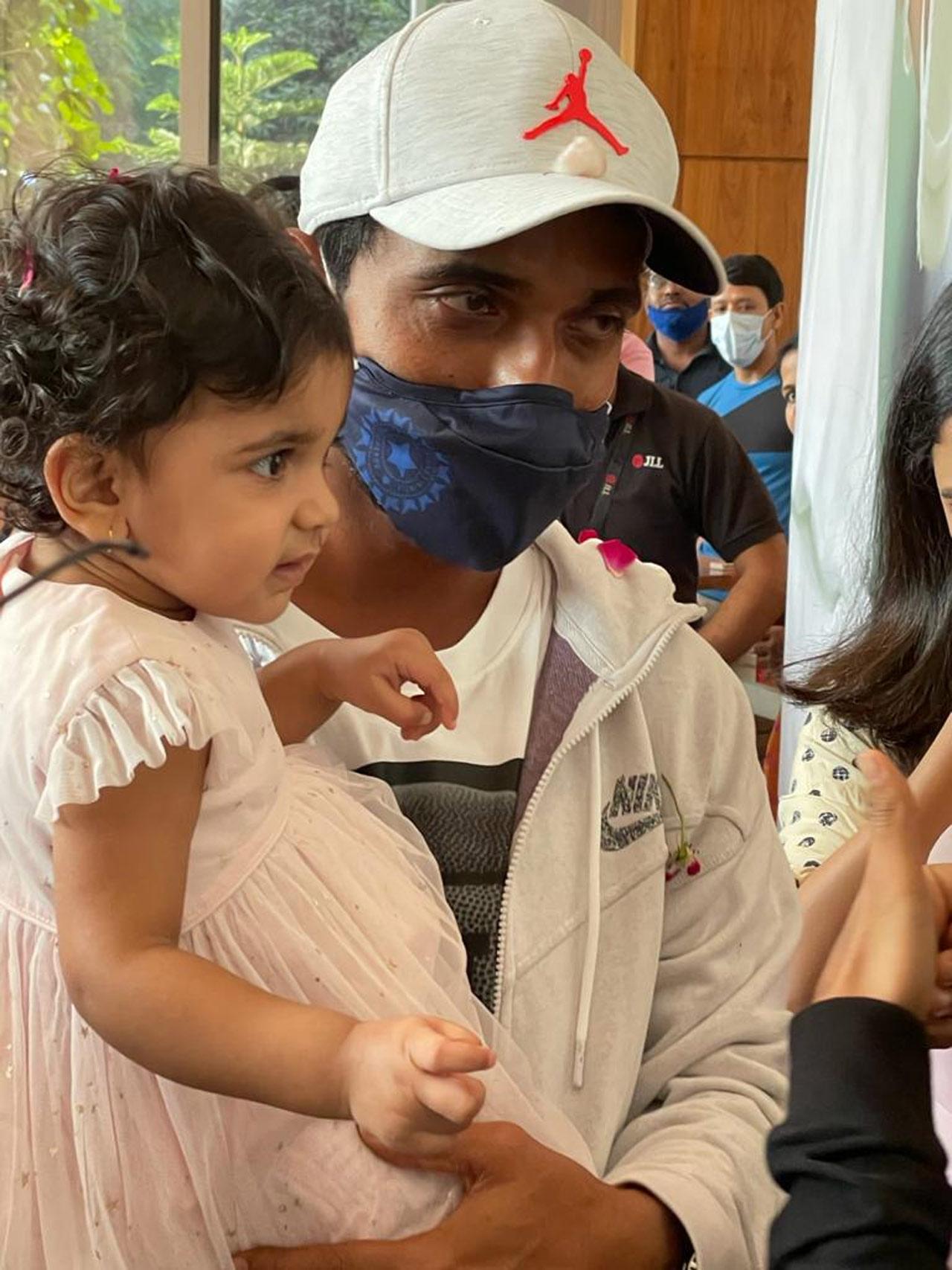 Ajinkya Rahane poses along with his daughter Aarya after he was given a warm welcome by his society members in Matunga. Picture/ mid-day reader Shripal Sangvi