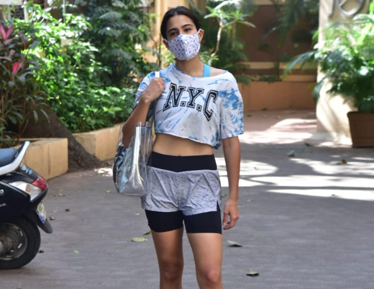 Sara Ali Khan looked chic in her white crop top and grey shorts as she was snapped outside her gym in Bandra, Mumbai. She opted for a white designer mask to prevent the spread of COVID-19. (All pictures: Yogen Shah).