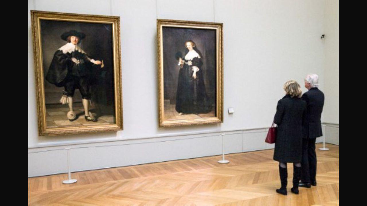 Visitors look at two full-length wedding portraits of Amsterdam couple Oopjen Coppit (R) and Marten Soolmans by Rembrandt. The paintings were bought in a collaboration between the Rijksmuseum and the Louvre Museum. It was displayed at the Louvre Museum in Paris in 2016, as part of a two-day state visit of the King and the Queen of the Netherlands in France. Photo: AFP: Etienne Laurent