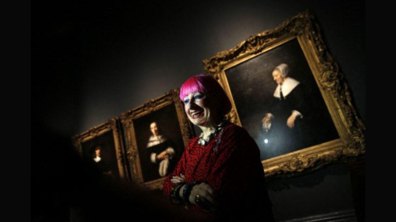 British fashion designer Zandra Rhodes poses for a picture in front of the painting 'Portrait of Catrina Hooghsaet' by Dutch artist Rembrandt at the National Gallery in London in 2014. The painting was a part of an exhibition 'Rembrandt: The Late Works', which explored the artist's final years of painting.  Photo: AFP / Adrian Dennis