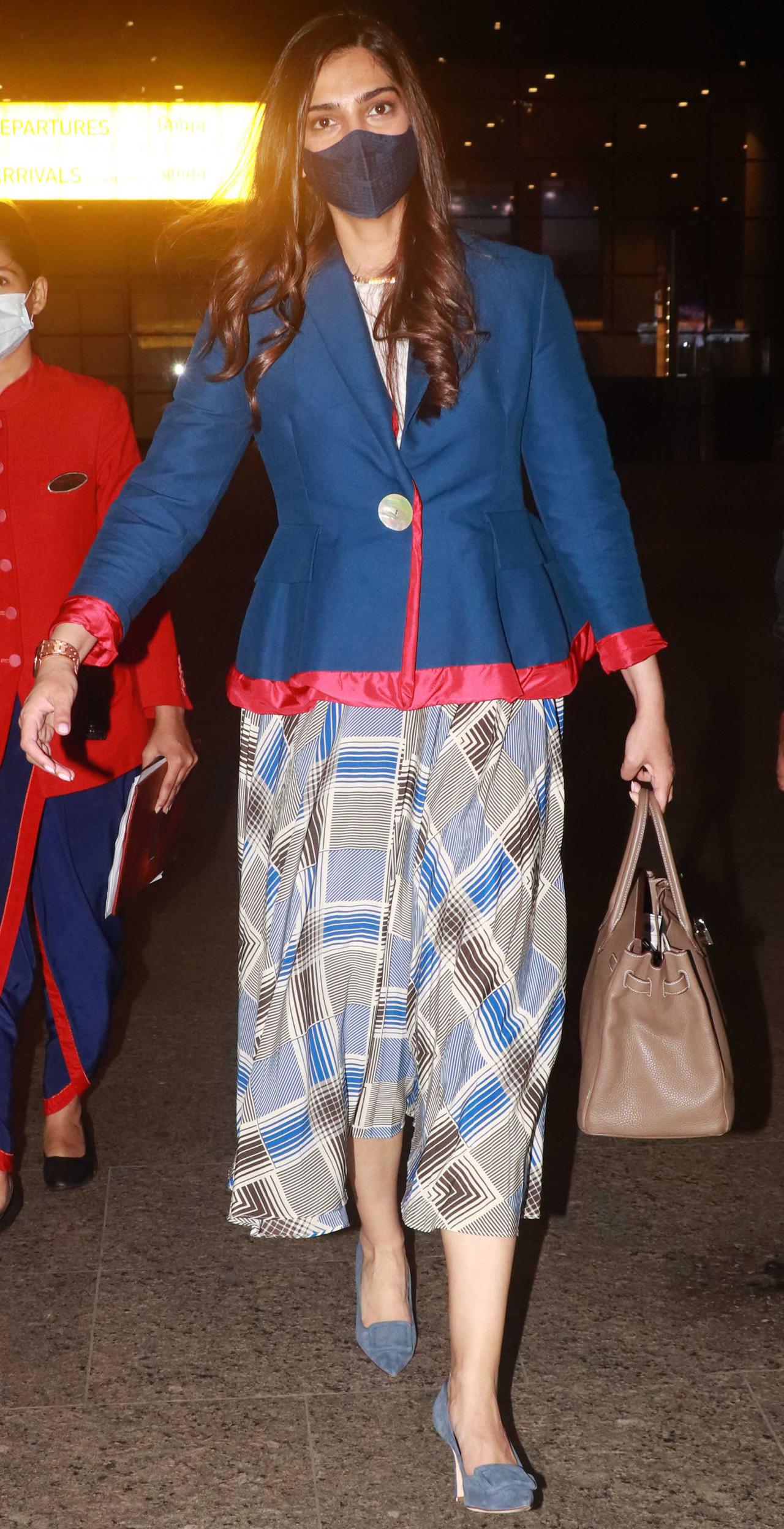 Sonam Kapoor Ahuja was clicked in a navy blue jacket and geometric printed dress as she arrived at the Mumbai airport. She returned to the bay after spending months in London.