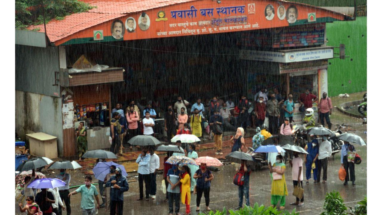 Commuters wait for bus during heavy rain at Bandongri in Kandivli. Pic/ Satej Shinde