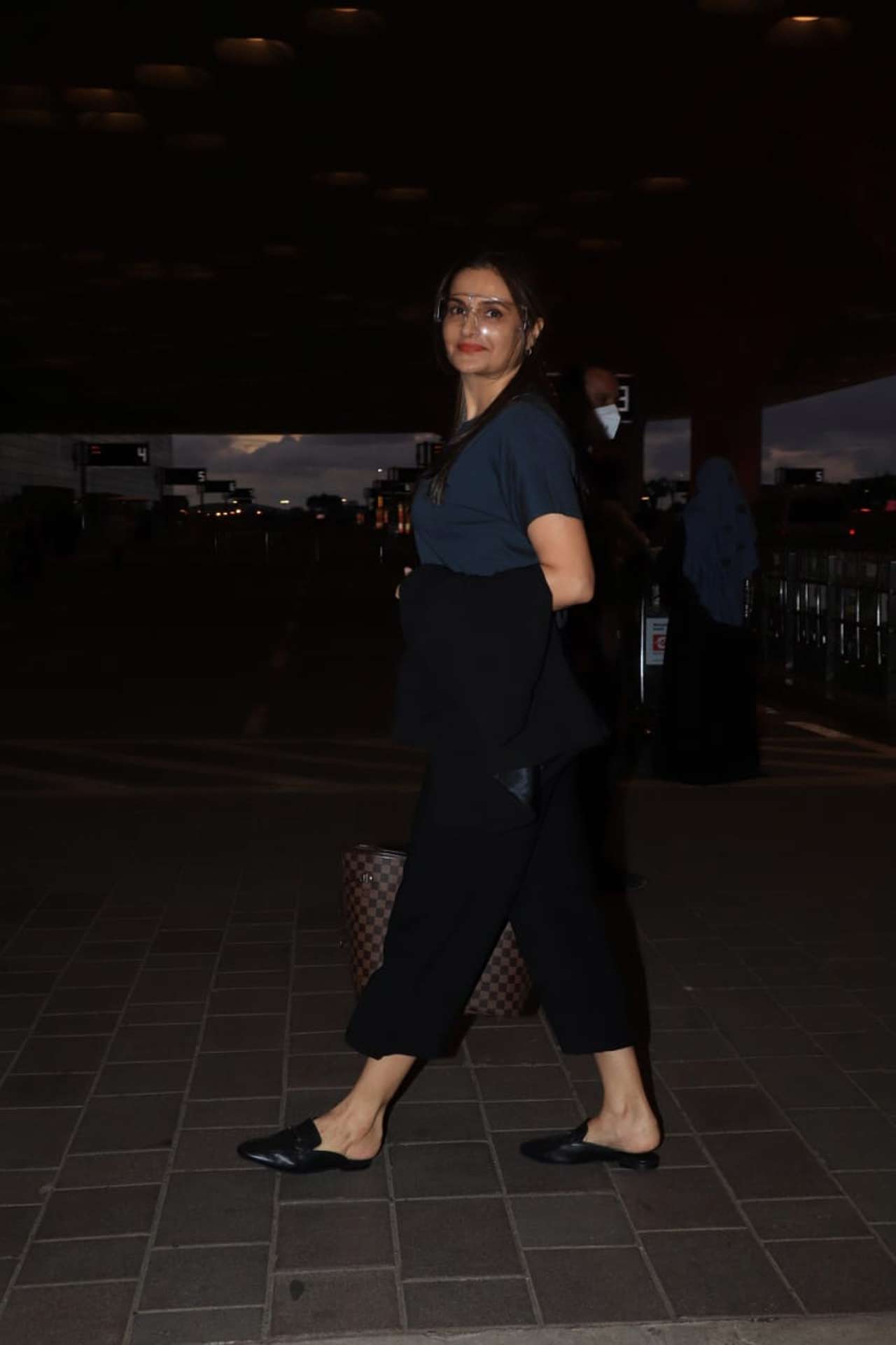Monica Bedi, the yesteryear actress, posed for the shutterbugs when snapped in at the Mumbai airport. The actress was out to attend an event in Delhi, and she opted for a grey t-shirt, paired with black wide-legged pants as her airport look.