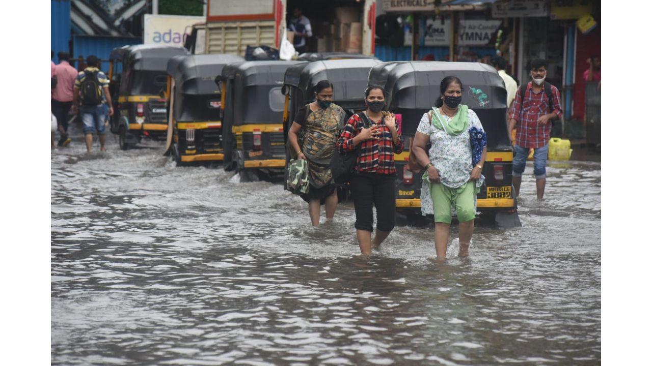 Commuters walk on a water-logged road at Amar Mahal Bridge in Chembur. Pic/ Sameer Markhende