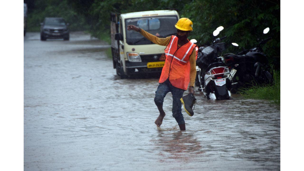 A BMC worker walks through a puddle as rains lashed Wadala on Monday. Pic/ Pradeep Dhivar