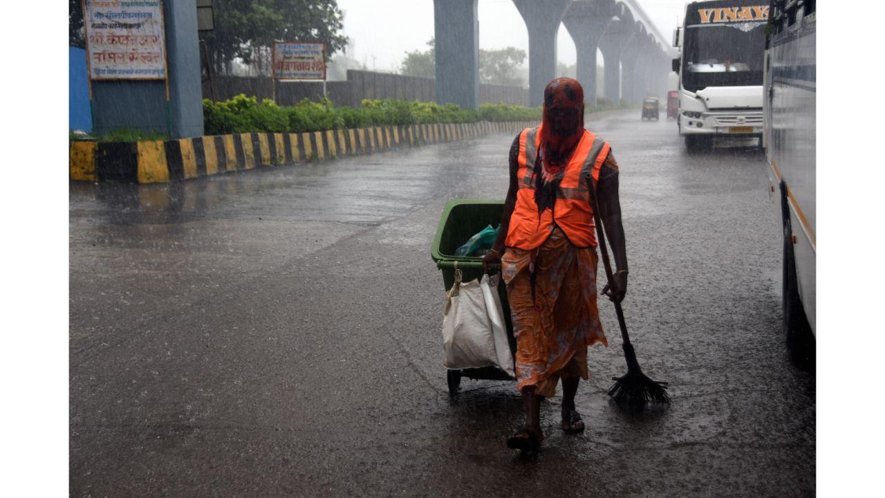 A civic sanitation worker gets drenched in rain at Wadala. Pic/ Pradeep Dhivar
