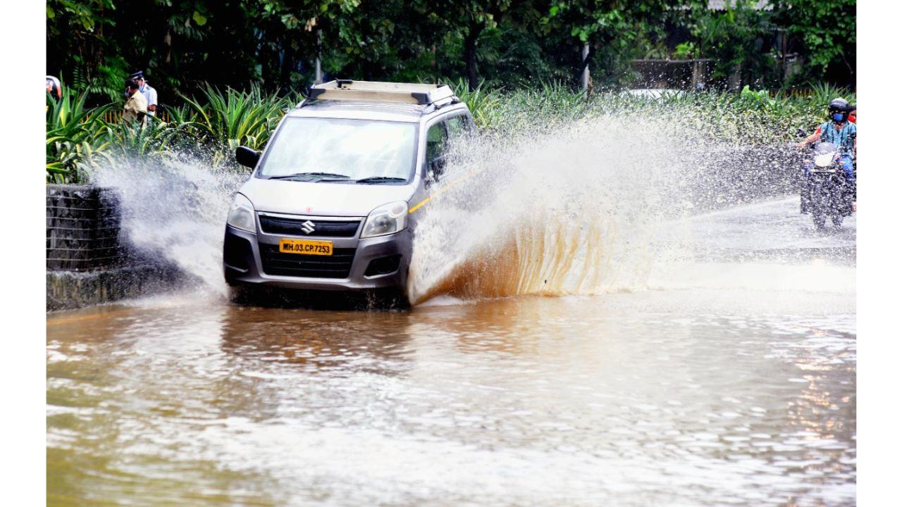 A car splashes water during heavy rains on Monday. Pic/ Shadab Khan
