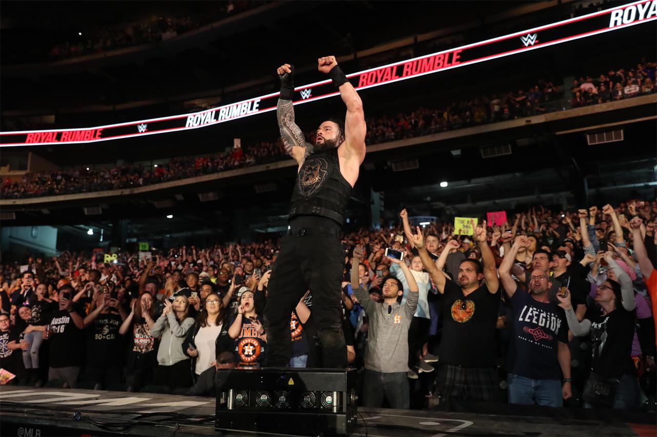 WWE Universal champion Roman Reigns celebrates his match victory as the WWE Universe joins in.