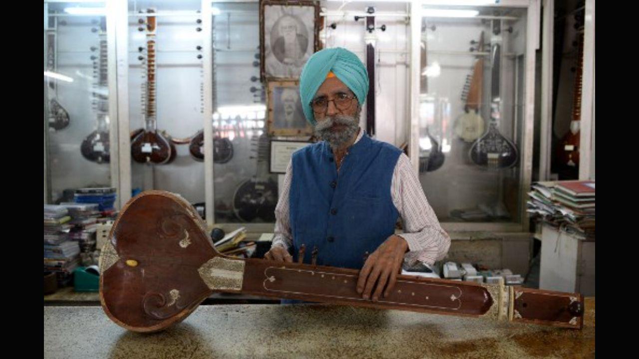 Ajit Singh, 86, owner of the music shop who fixed John Lennon's guitar and performed at George Harrison's 25th birthday party when the Beatles stayed at an ashram in Rishikesh in 1968, posing for a photo in Dehradun in northern India on June 19, 2018. Photo: AFP