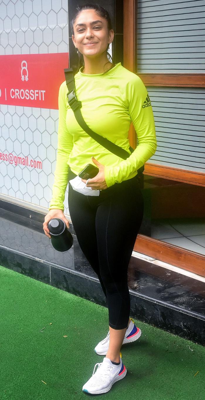 'Super 30' actress Mrunal Thakur aced the gym look in a neon yellow top and black gym pants as she posed for the photographers outside the fitness studio in Santacruz.