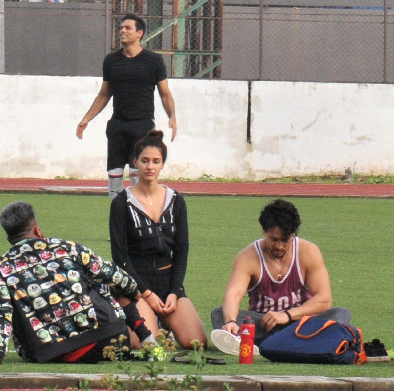 Disha Patani opted for a black jacket, paired with black shorts, while Tiger Shroff was seen in joggers and Ganji. Right behind the couple, can be seen actor-anchor Sameer Kocchar warming up for the match.