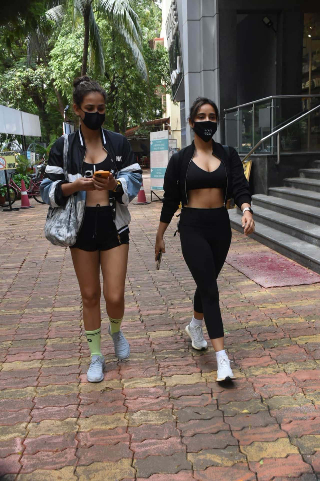 Sharma sisters - Ayesha and Neha were spotted near their residence in Bandra, Mumbai. Ayesha stunned in black yoga shorts, paired with a black sports bra and a bomber jacket during the outing. Speaking of Neha's athleisure, the Crook actress' all-black look is truly winning the hearts. All pictures/Yogen Shah