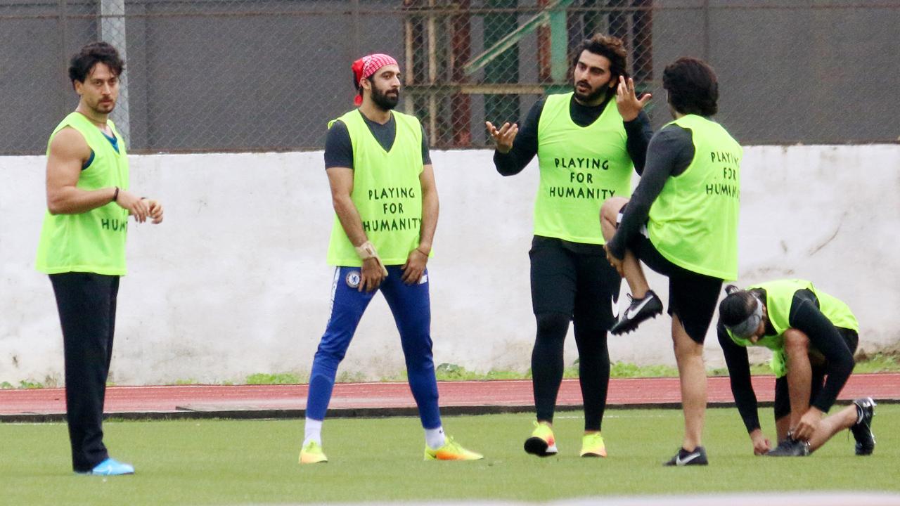 A candid picture of Arjun Kapoor, Tiger Shroff and their friends while the gang was having a conversation after the game.