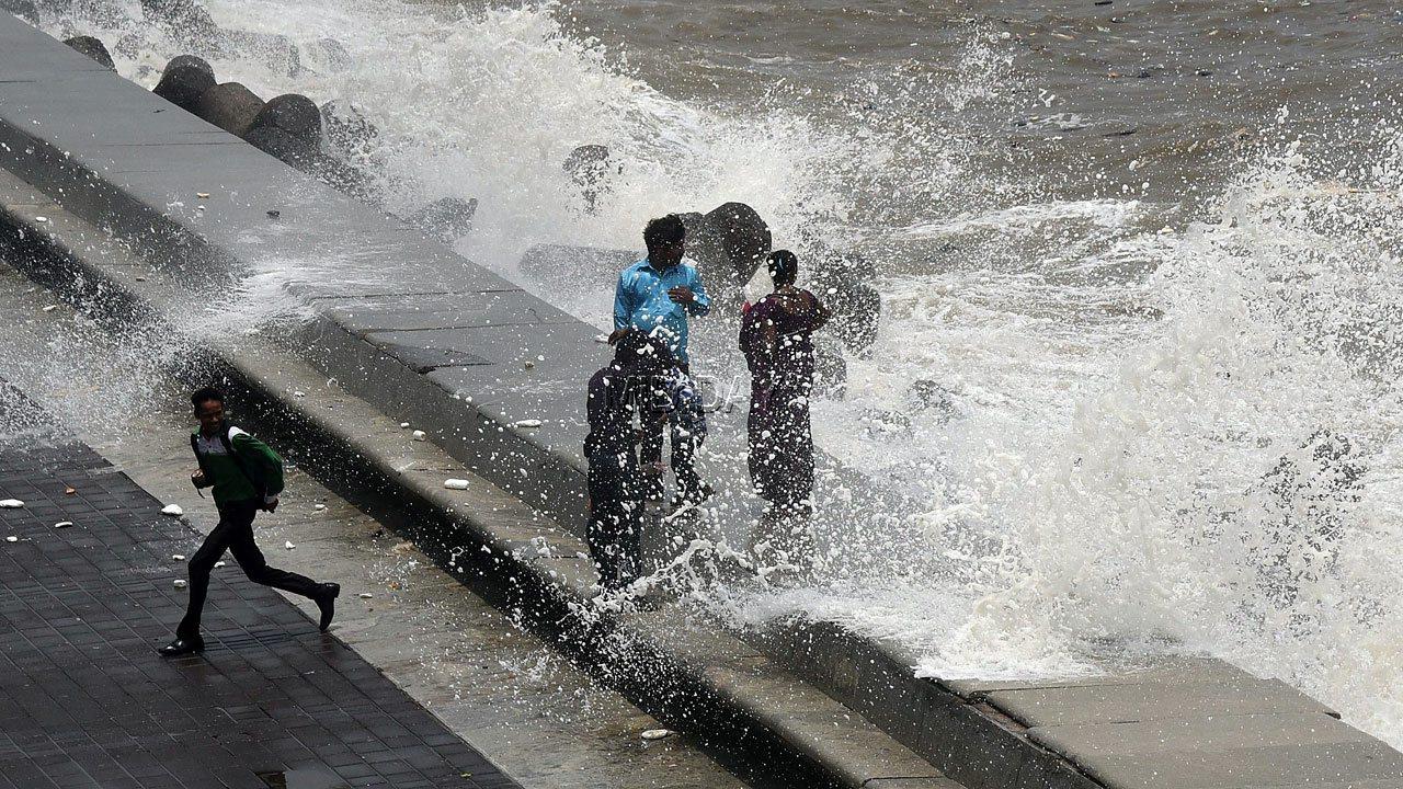 Despite warnings from the civic body to not venture near the sea, some citizens choose to ignore the alert during high tide at the Marine Drive promenade on June 24, 2017. Pic: Suresh Karkera