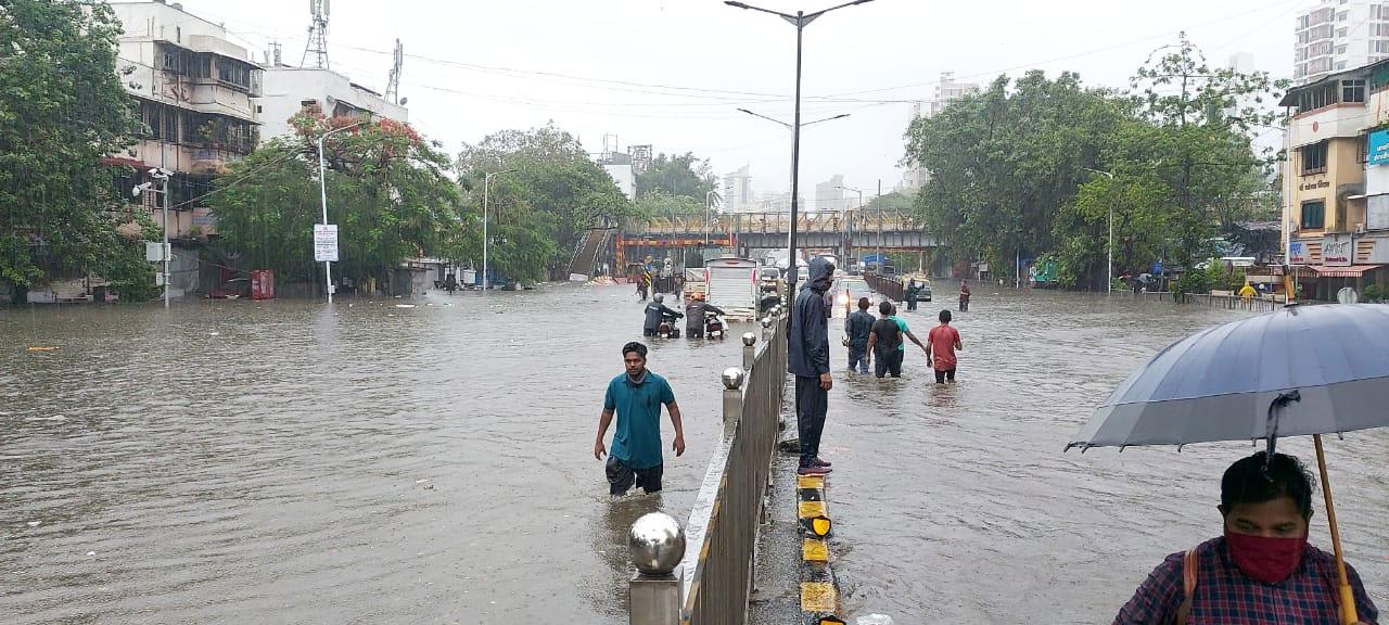 People walk in flooded street near King's Circle station in Mumbai. Photo: Rajendra Aklekar