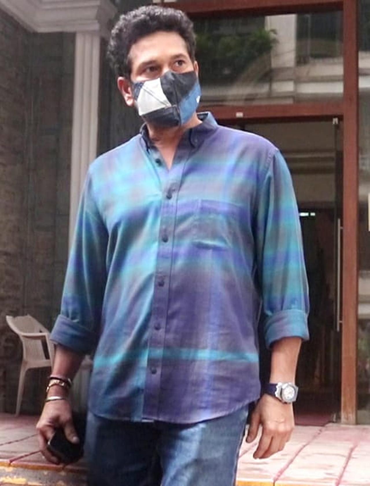 Sachin Tendulkar was seen wearing a mask with a design and had worn a dark blue shirt along with blue denims 