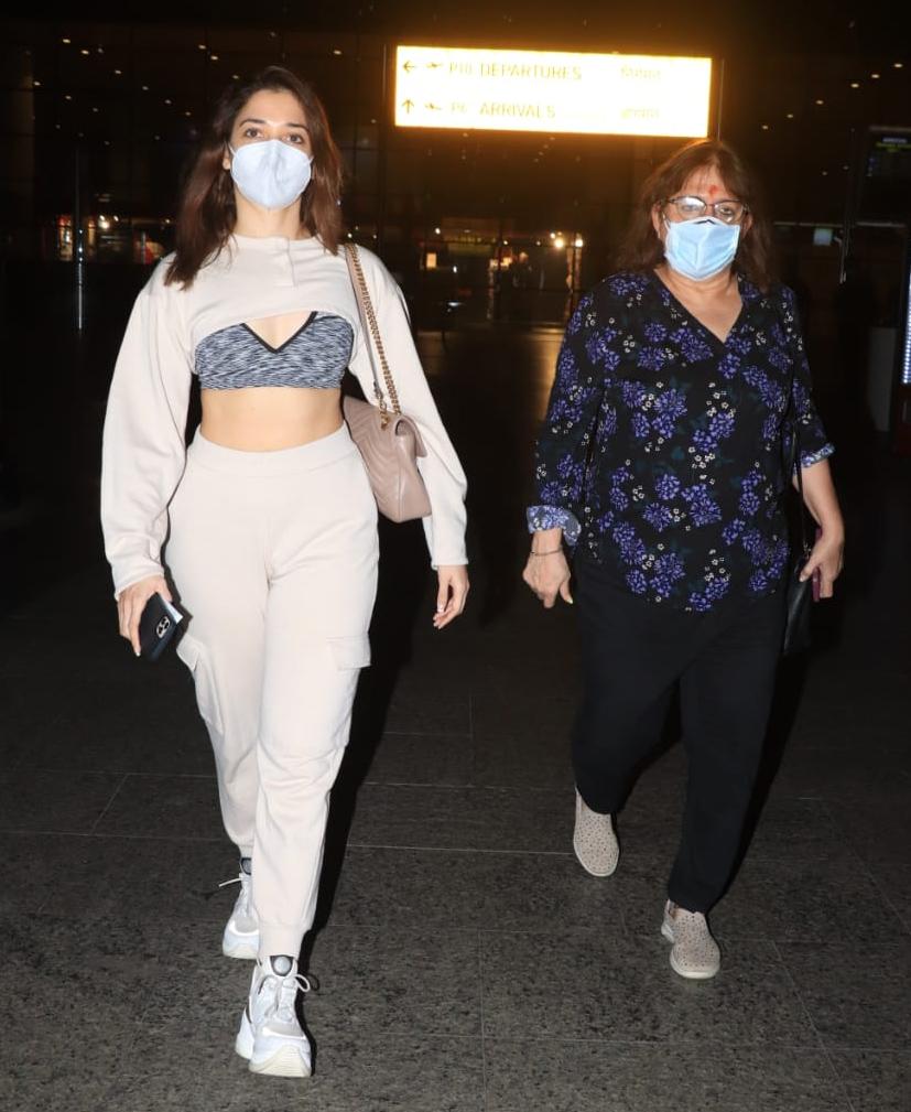 Tamannaah Bhatia was spotted with her mother at Mumbai airport. The actress surely knows how to make heads turn when it comes to fashion. Her travel look comprised of beige track pants, paired with a cropped sweatshirt teamed with a grey bralette, which flaunted her toned torso.