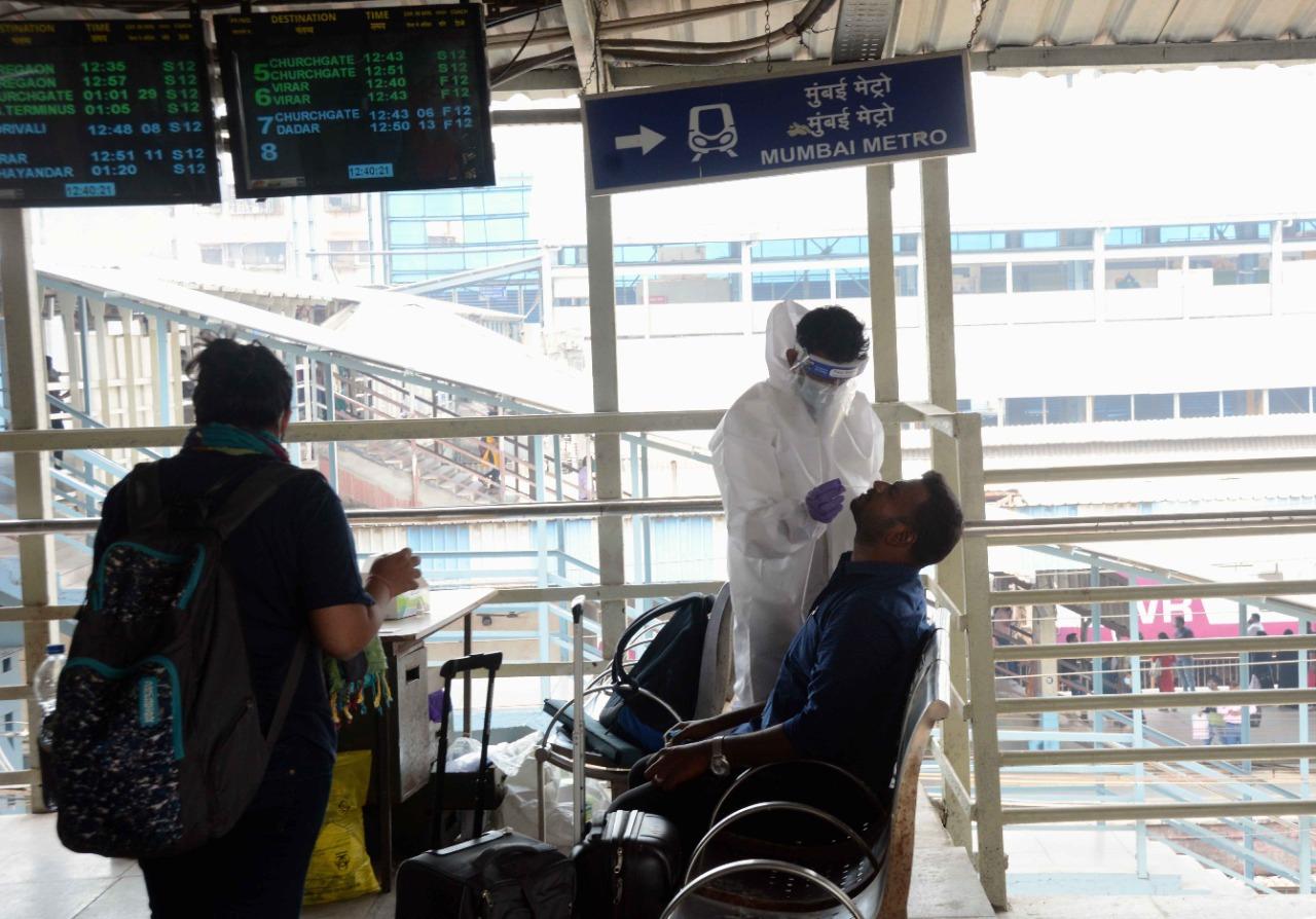 Healthcare officials conduct tests of passengers arriving at Andheri railway station amid the rise in COVID-19 cases in the city. Photo: Satej Shinde