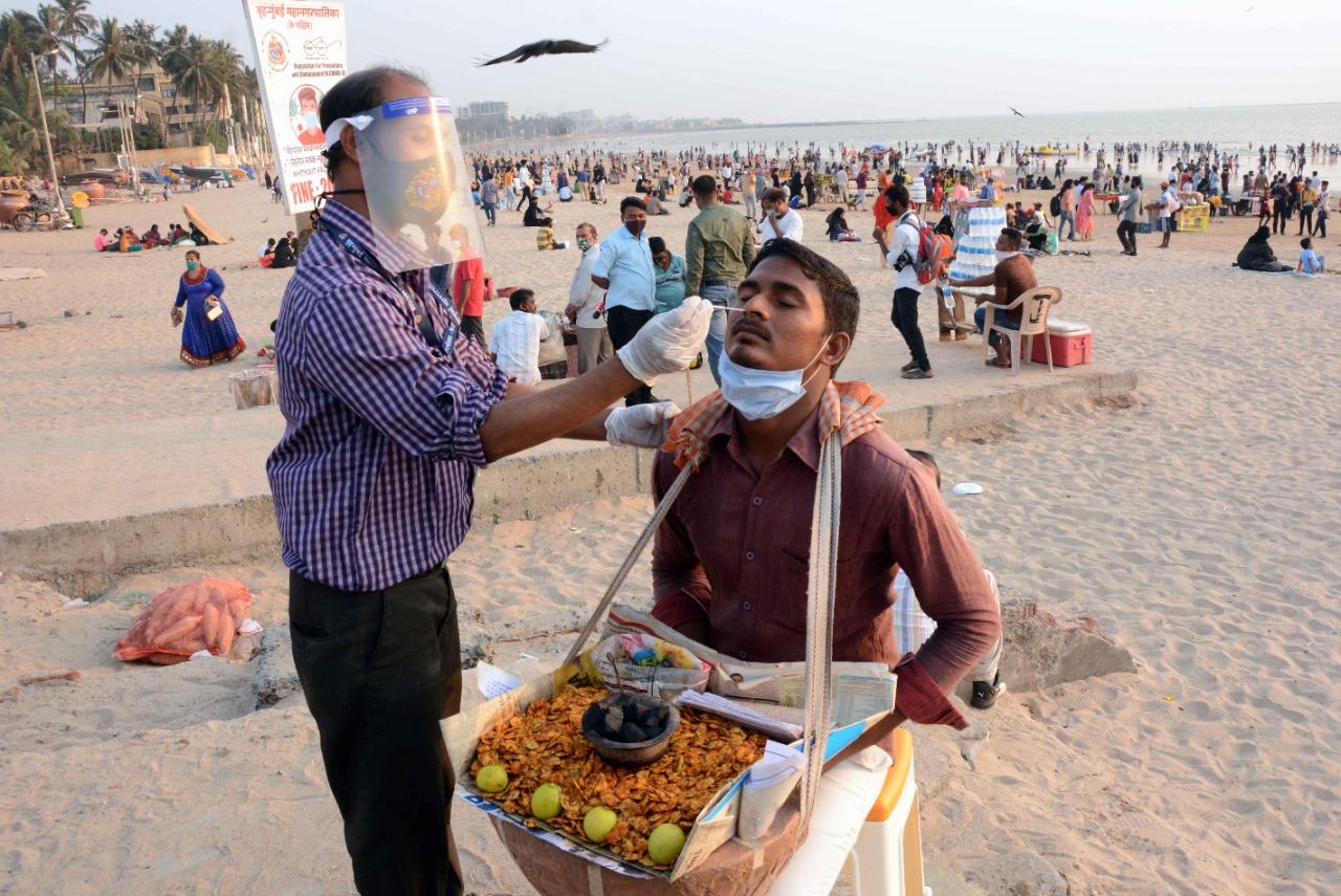 A BMC healthcare worker testing a hawker at Juhu beach on 27 March. The civic body has been carrying out random tests in the city. Photo: Satej Shinde