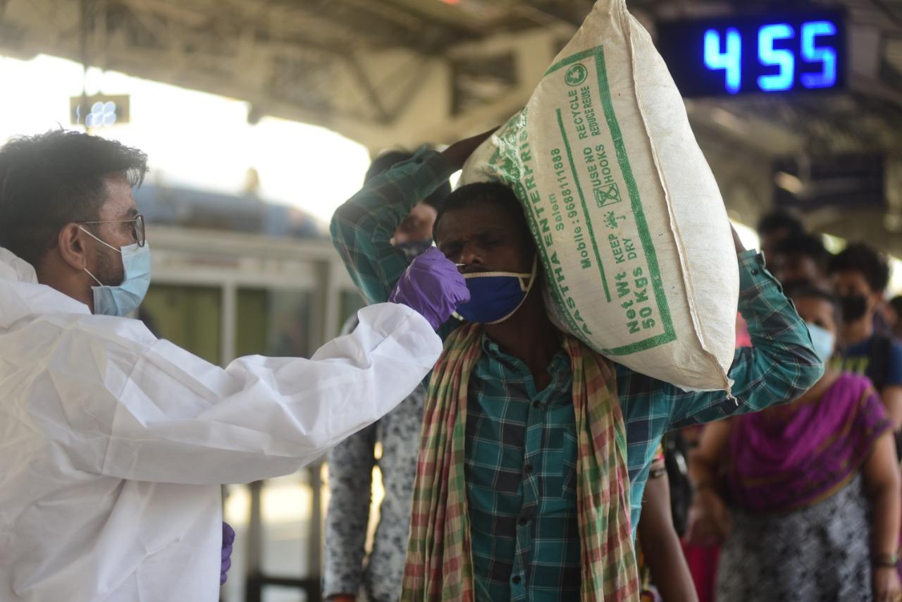 A health worker takes a nasal swab sample of passengers arriving from other states as part of a mandatory COVID-19 coronavirus Rapid Antigen Test (RAT) at Lokmanya Tilak railway terminus. Photo: Atul Kamble