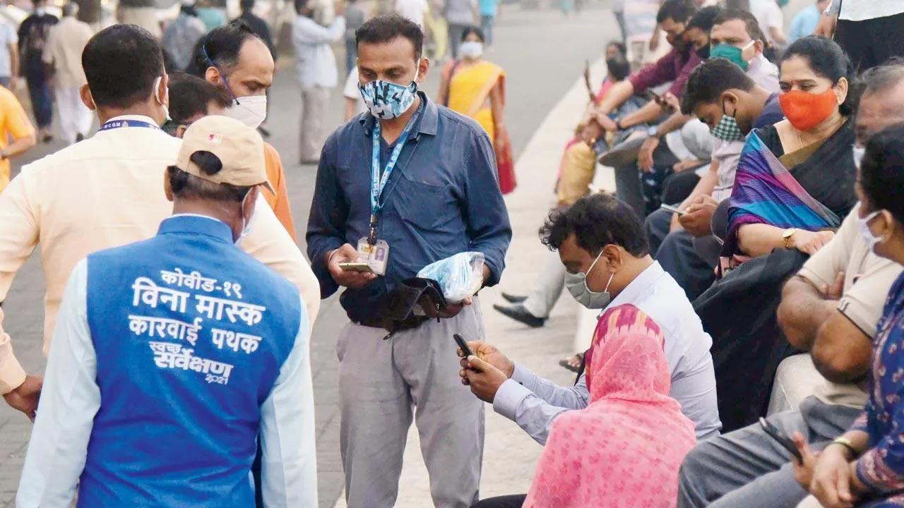 After the Uddhav Thackeray-led Maharashtra government issued revised guidelines for phase-wise opening and easing of lockdown restrictions at the end of lockdown 4.0, hundreds of joggers were seen enjoying their morning and evening walks. Many were seen posing for selfies without face masks and flouting social distancing norms.
In pic: BMC's clean-up marshals fine maskless people at Marine Drive. Pic/Suresh Karkera