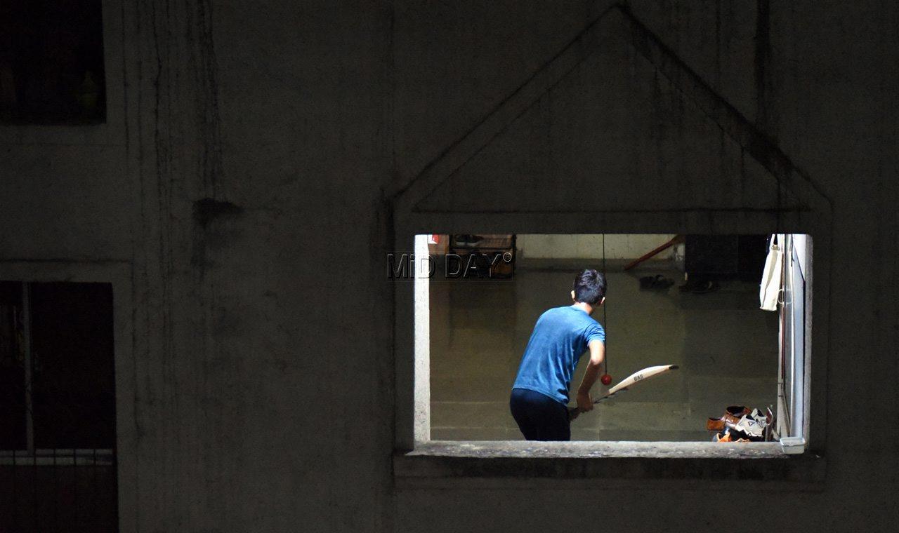 A boy practising cricket in the hallway of his residential building in Borivli, Mumbai on April 26, 2020. PIC/NIMESH DAVE