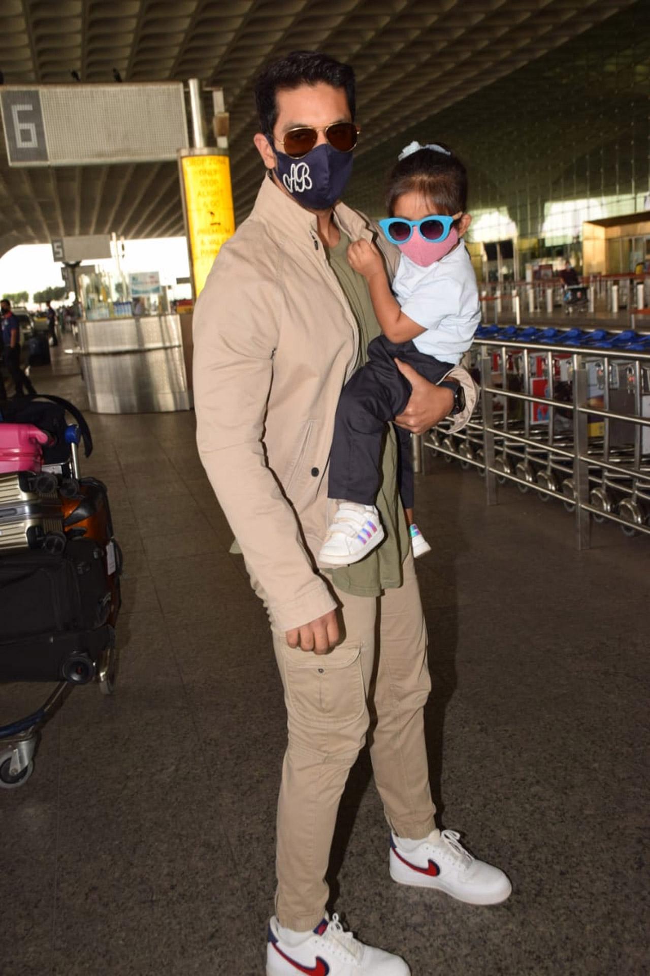 Angad Bedi was clicked with his daughter Mehr Dhupia Bedi at Mumbai airport. The father-daughter duo, who completed covered their faces with mask and sunglasses, got clicked in a rather amusing pose.