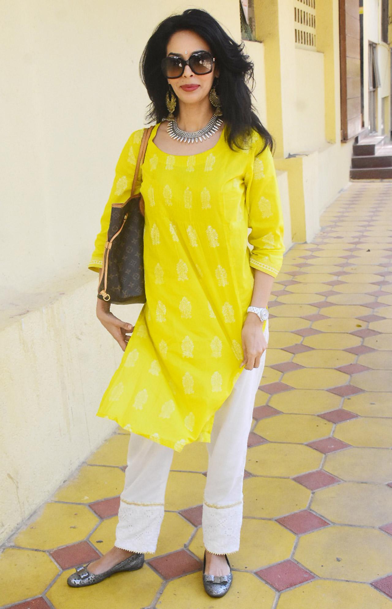 Mallika Sherawat looked fresh as a daisy, as she went out and about in Bandra, Mumbai. The gorgeous actress opted for a yellow Kurti, white palazzo and teamed up junk jewellery to complete her look.