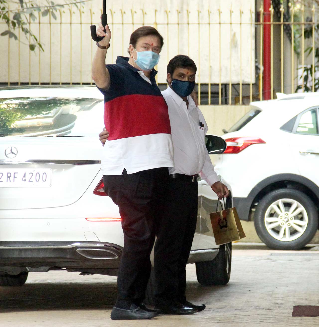 Randhir Kapoor waved at the paparazzi when snapped by the shutterbugs in the city. The yesteryear actor arrived with a gift, along with his Man Friday.