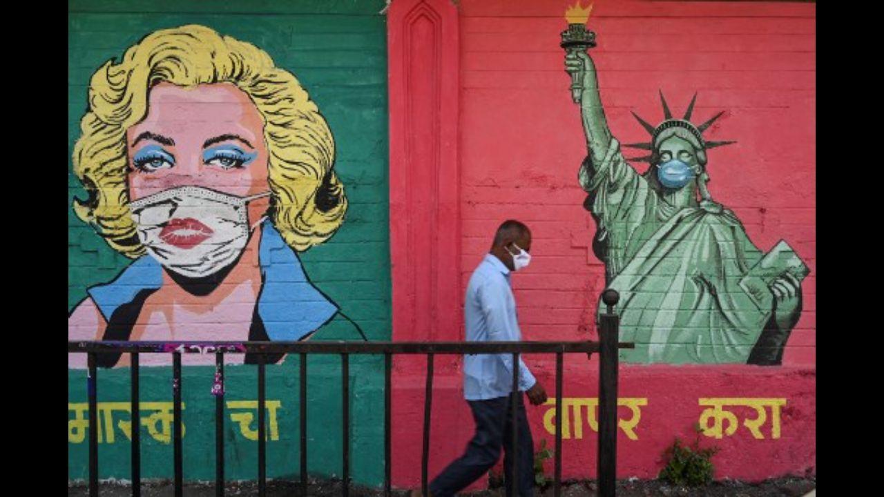 A pedestrian walks past a mural of Hollywood actress Marilyn Monroe (L) and the iconic 'Statue of Liberty', both painted with their faces covered for Covid-19 protection, in Mumbai on March 31, 2021.
Photo: AFP