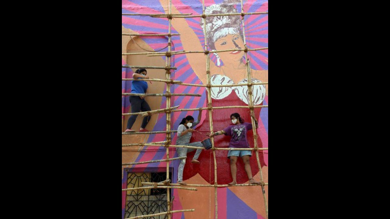 Artists wearing face masks paint a wall mural of Bollywood cabaret queen and actress Helen on a residential building in Mumbai on May 14.
Photo: AFP