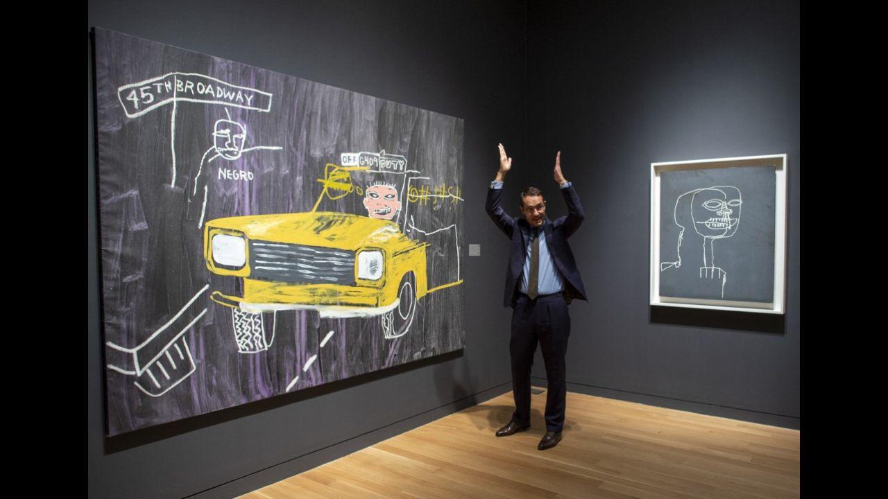 A Sotheby's employee talks about Andy Warhol and Jean-Michel Basquiat's 'Taxi, 45th Street' (L) and Jean-Michel Basquiat's 'Untitled' on November 2, 2018 at Sotheby's Auction house in New York.
Photo: Don Emmertt / AFP
