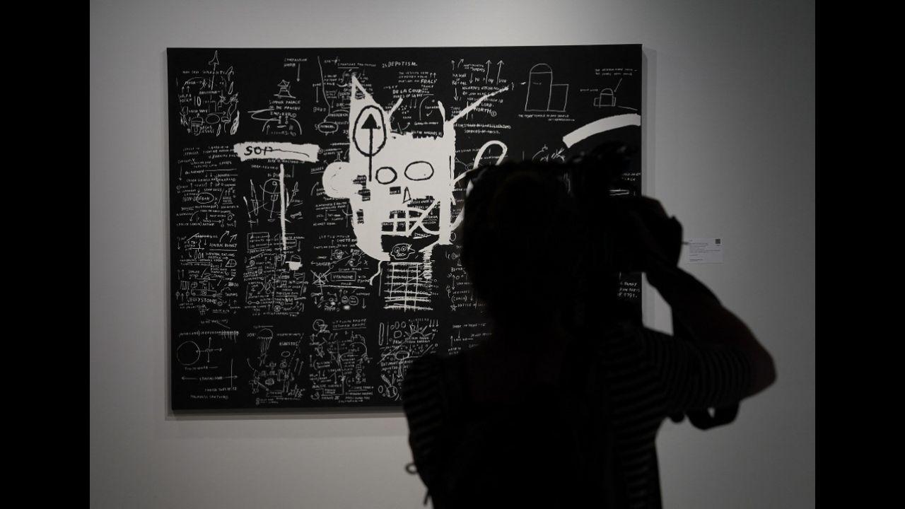 A person looks at Jean-Michel Basquiat's 