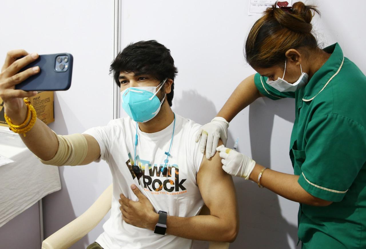 In picture: A man clicks a selfie while a healthcare worker administers a COVID-19 jab to him at the BKC vaccination centre in Mumbai. Photo: Shadab Khan