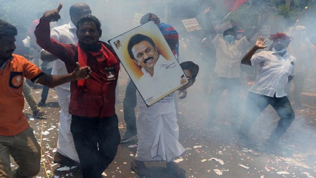 Members of the Dravida Munnetra Kazhagam (DMK) without face masks celebrate while holding a picture of DMK leader M.K. Stalin after their party's lead in major seats of the Tamil Nadu assembly elections. Photo/AFP