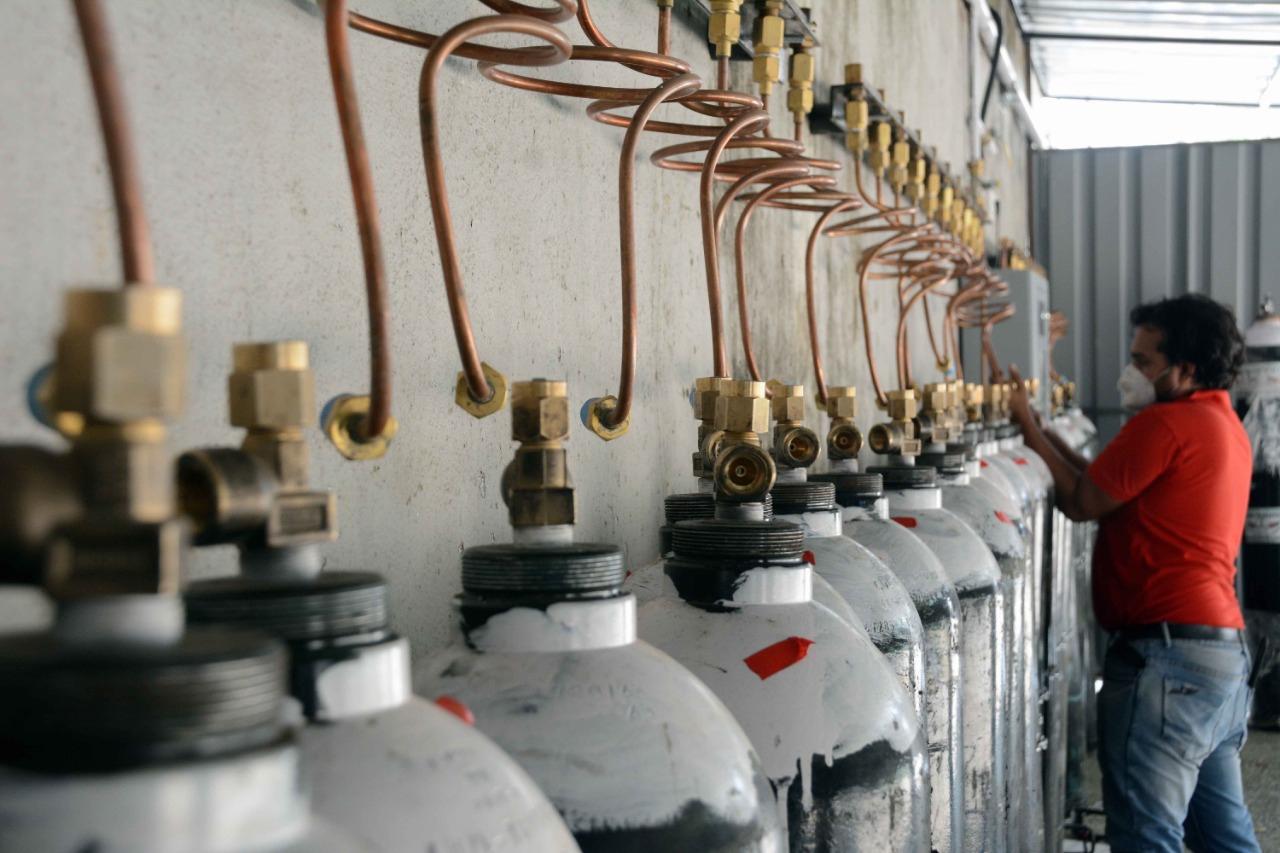 A worker connects a pipeline to an oxygen cylinder in the oxygen manifold room outside BMC's newly developed COVID-19 care centre at MCGM NESCO Jumbo COVID-19 Facility in Goregaon. Photo: Satej Shinde