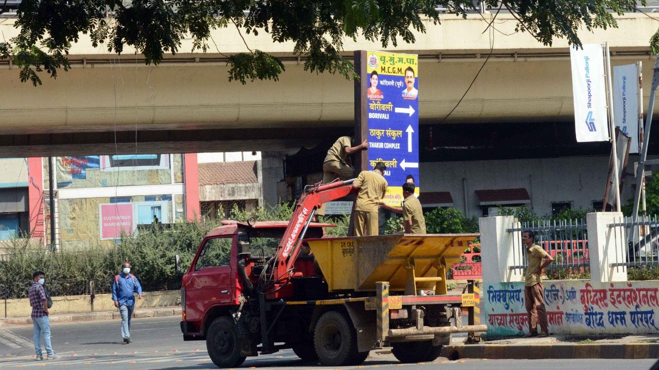 Along with Covid-19 management, the civic body carried out other essentials tasks in the city. 
In picture: BMC workers removing illegal posters at Western Express Highway, Kandivli in Mumbai. Pic: Satej Shinde