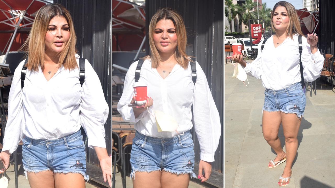 Rakhi Sawant was spotted at, what seems to be her favourite, coffee shop in Lokhandwala, Andheri. The actress donned a perfect summer look - an oversized white shirt paired with blue denim shorts. Rakhi did not miss a single chance to give some wacky expressions for the paparazzi.