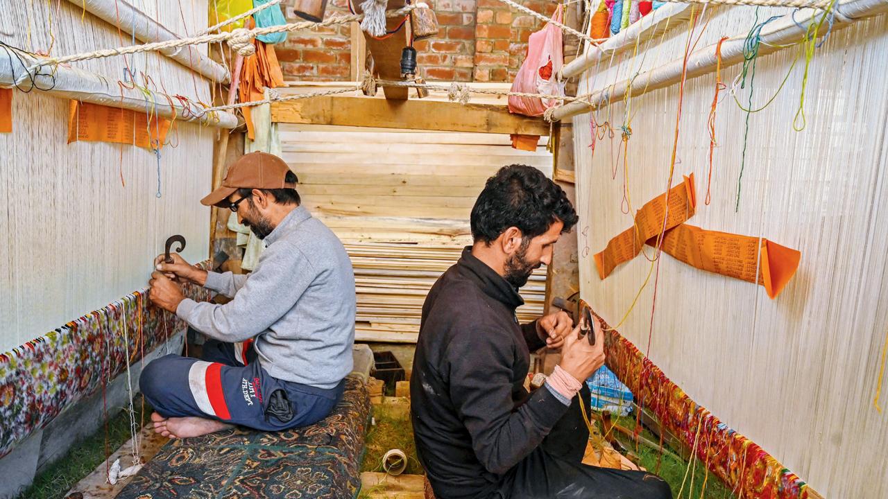 Traditional Kashmiri artisans seen weaving silk carpets at a factory in Srinagar. Pic/Getty Images