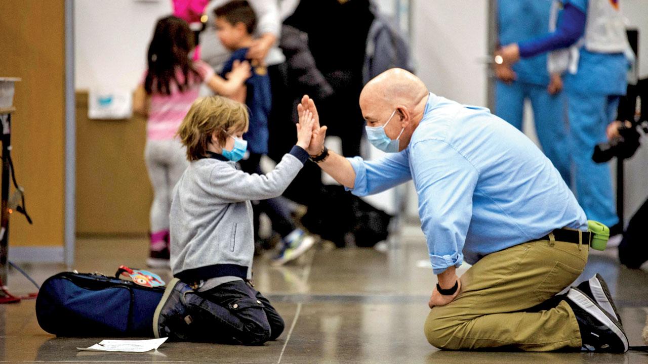A health care worker high-fives a child who just received the Pfizer-BioNTech vaccine for children in Montreal, Canada on Wednesday, the first day that kids between 5-11 years were allowed it. Pic/AFP