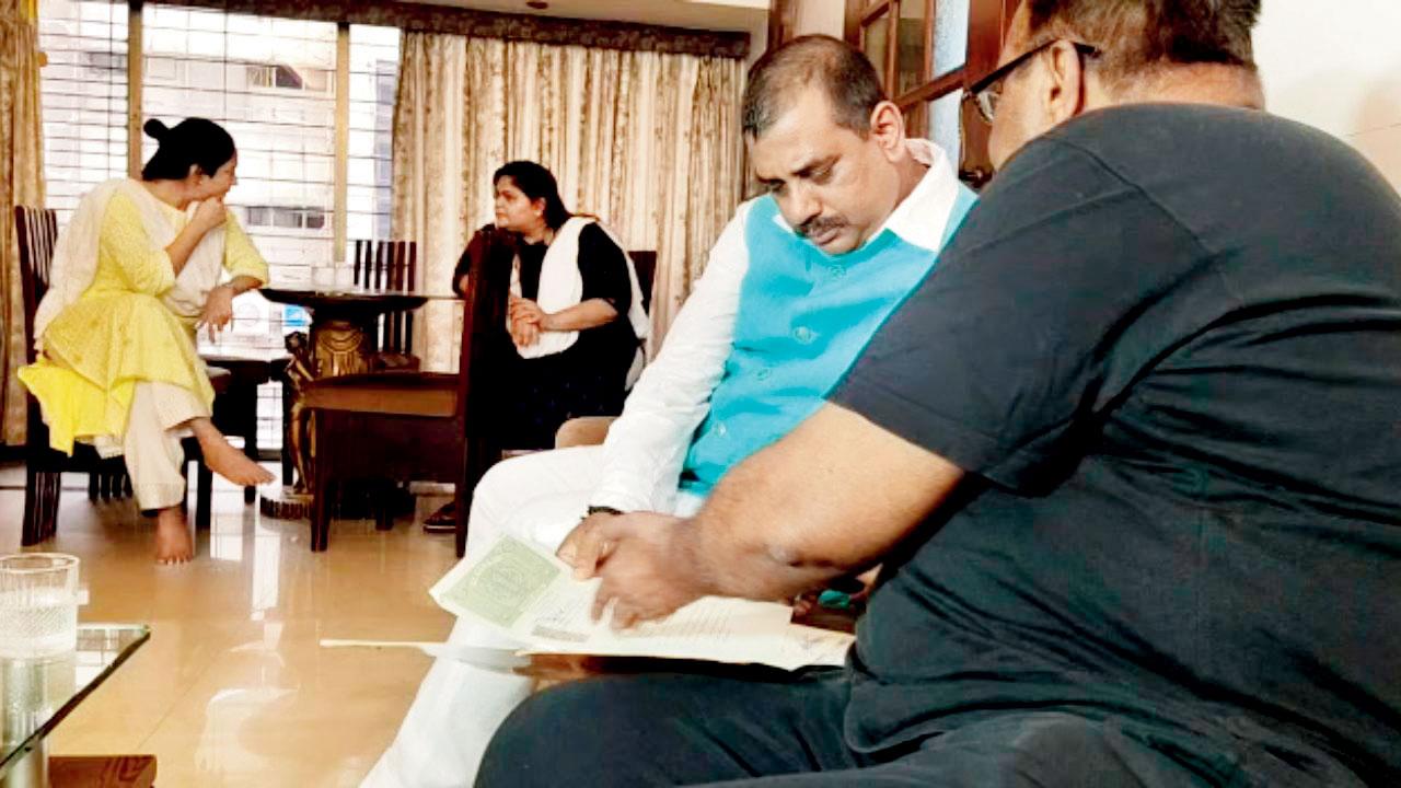 Wankhede’s father (in black T-shirt) shows documents to the NCSC official