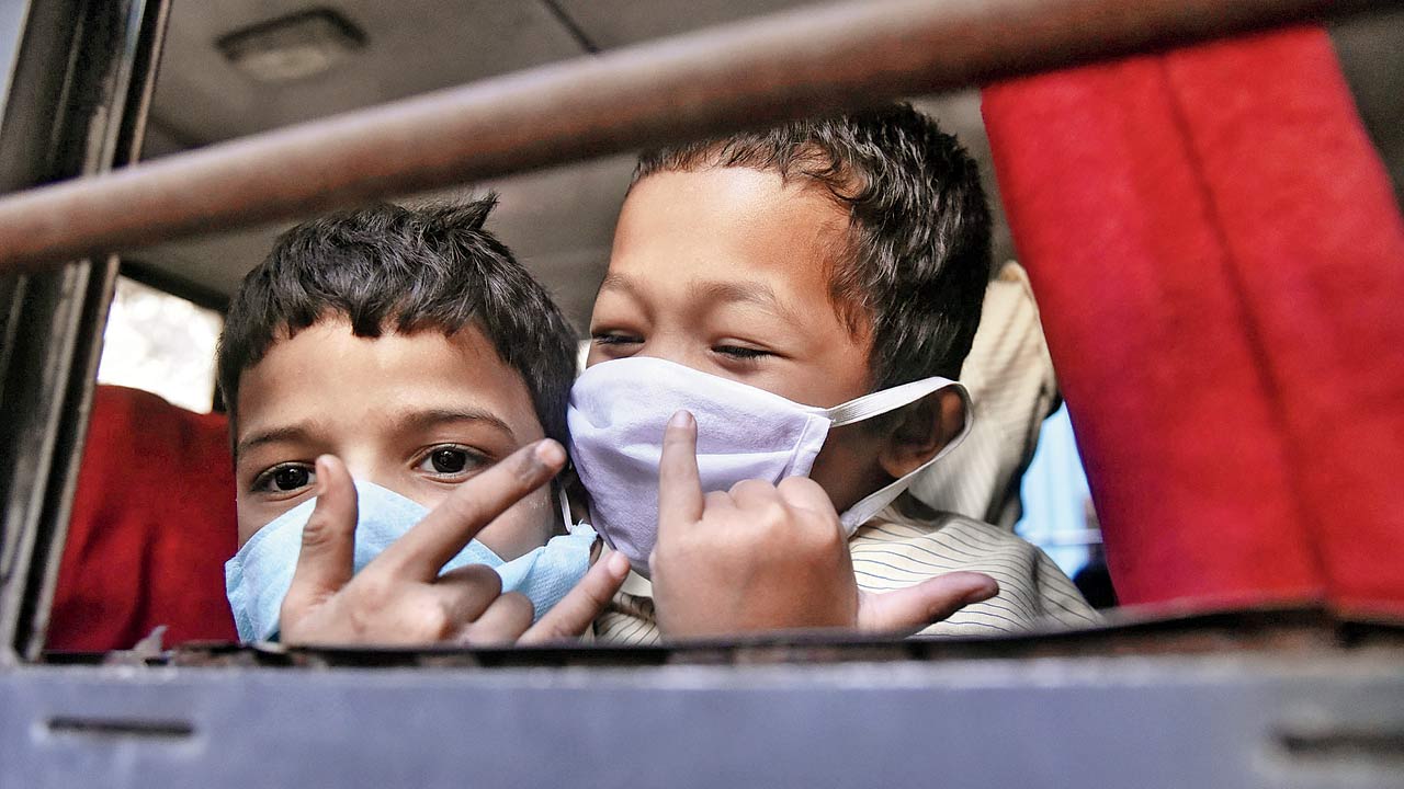 Schoolkids, wearing masks, on a bus in Bandra, in March 2020. Pic/Pradeep Dhivar