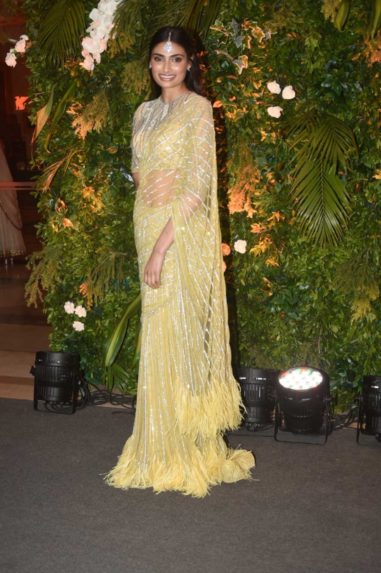 Athiya Shetty wore a yellow saree that had geometric patterns in silver. The pallu and the hem of the saree had tassels. A silver embroidered blouse, a silver maang-tikka with delicate earrings completed her look.