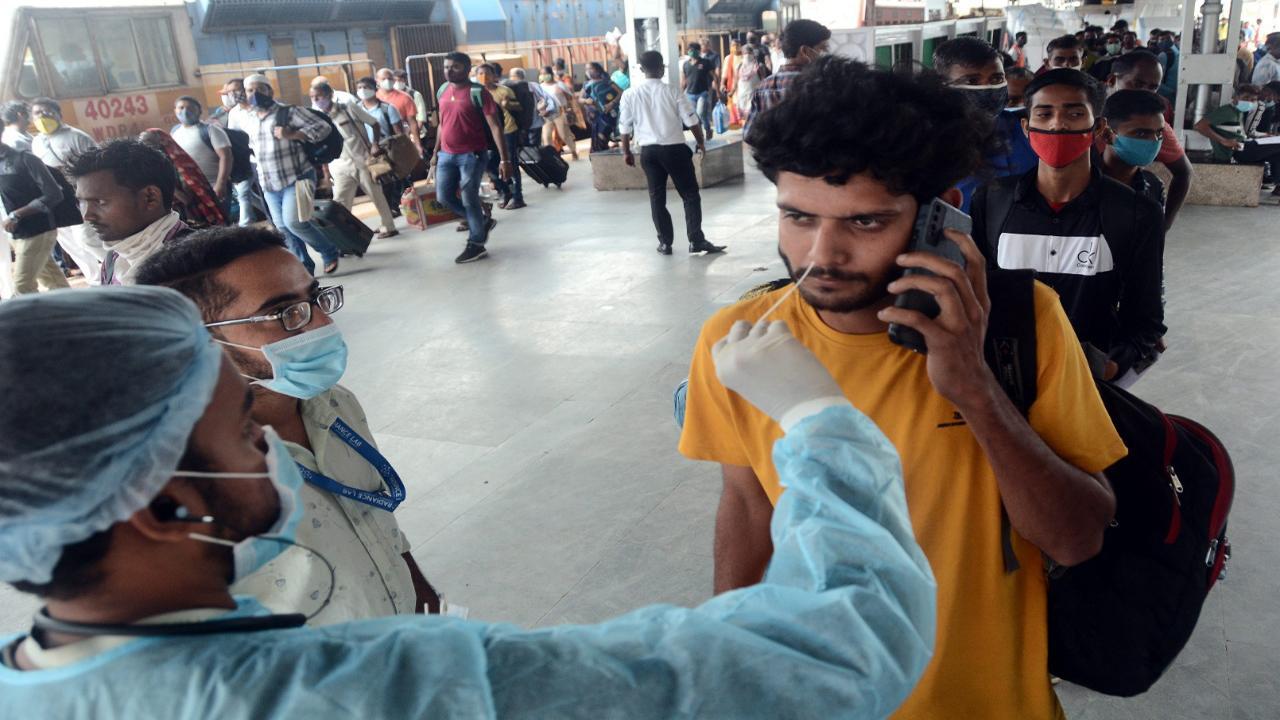 A health worker collecting swab test of a commuter in Mumbai.