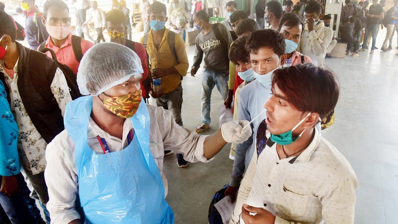 A health worker collects a swab sample from a passenger at the LTT on Sunday. Pic/Shadab Khan