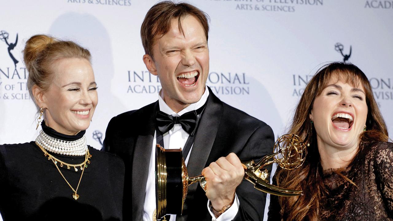 Swedish actress Sofia Helin, Norwegian director Alexander Eik and producer Silje Hopland Eik pose with their award for  Atlantic Crossing. Pic/AFP