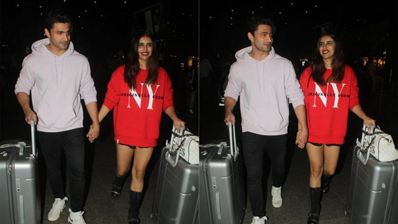 Ieshaan Sehgaal and Miesha Iyer smile and hold hands as they arrive in the city from Goa