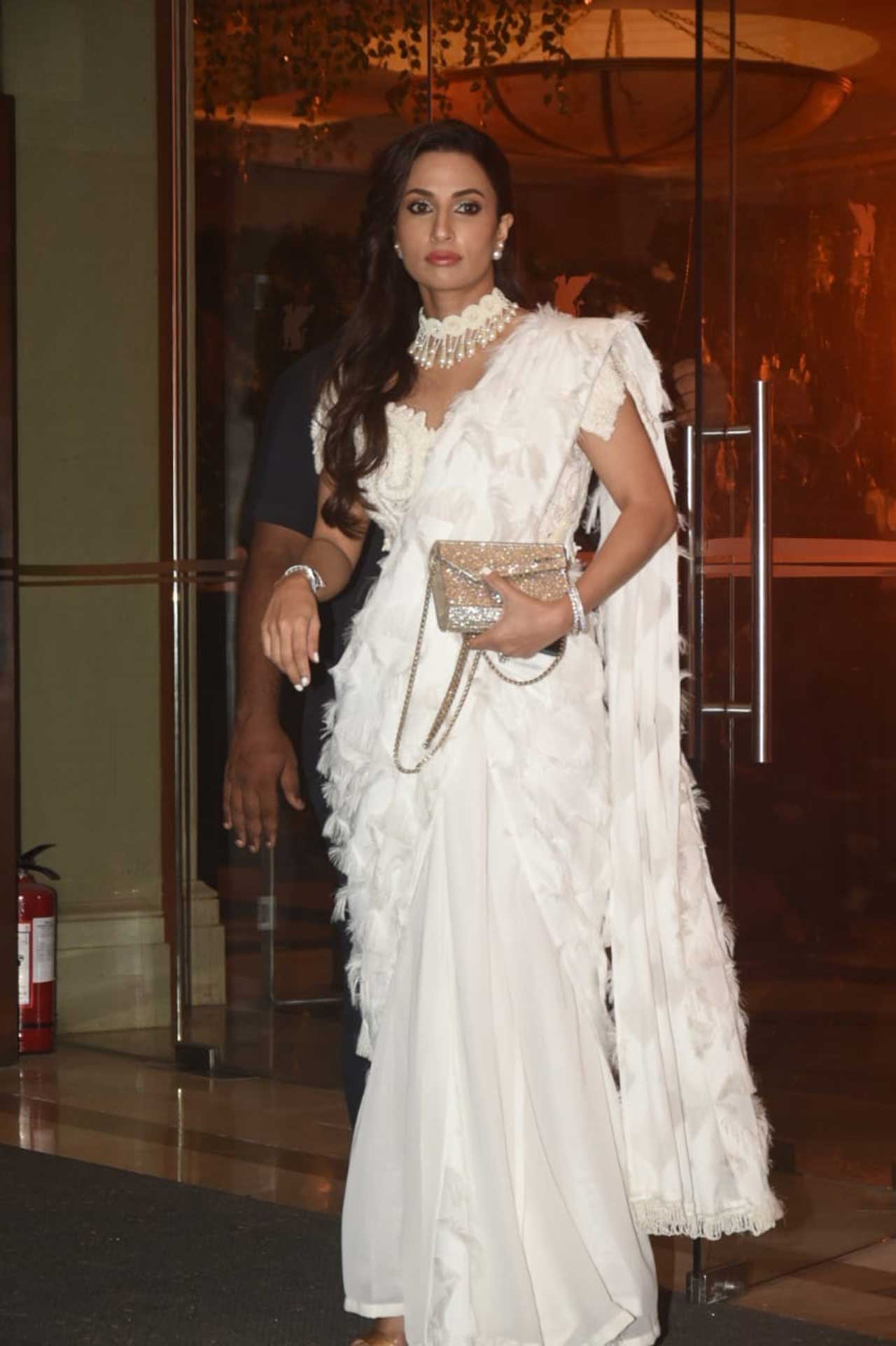 Athiya Shetty's mother was a vision in an all white ruffled saree with a white choker necklace and matching earrings. 
